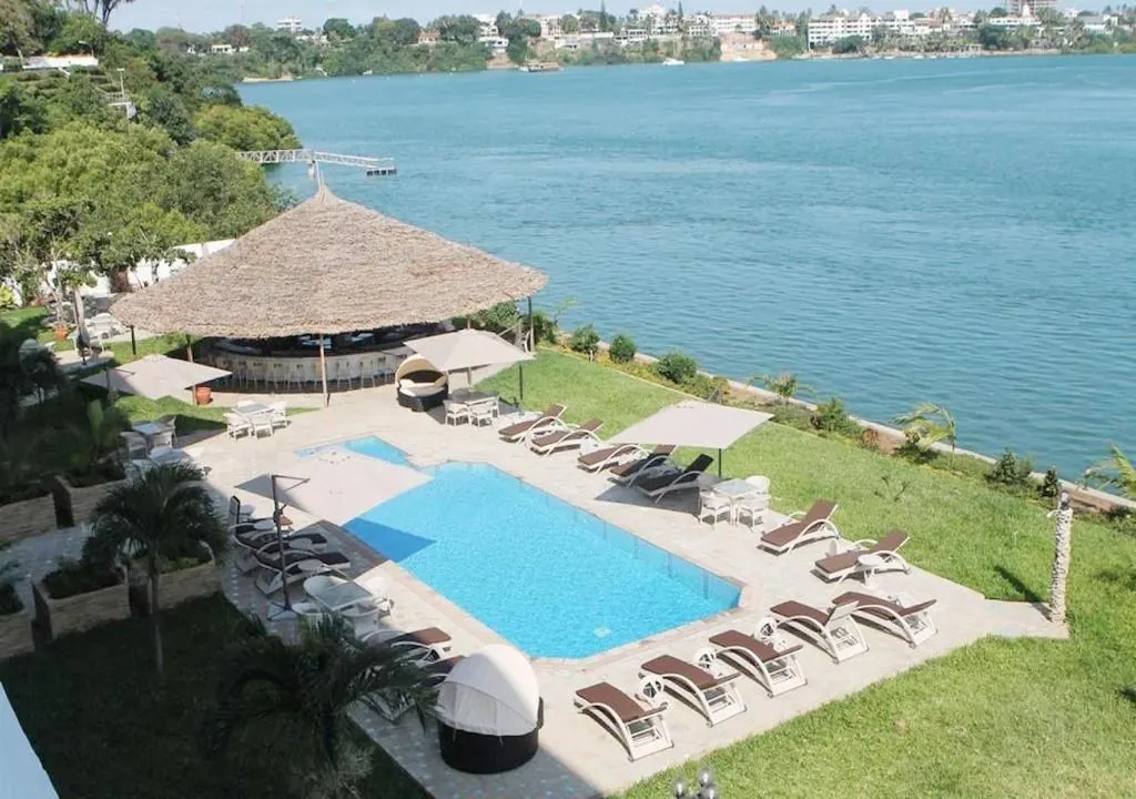 Swimming pool and thatched bar beside Tudor Creek at CityBlue Creekside